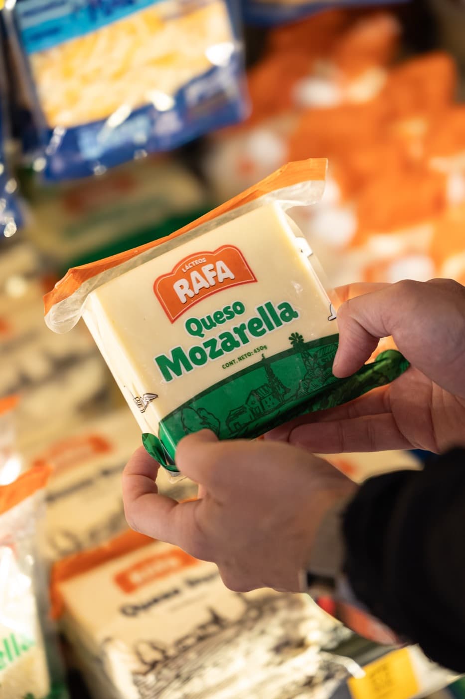 Mano tomando un queso mozzarella Lácteos Rafa en el supermercado