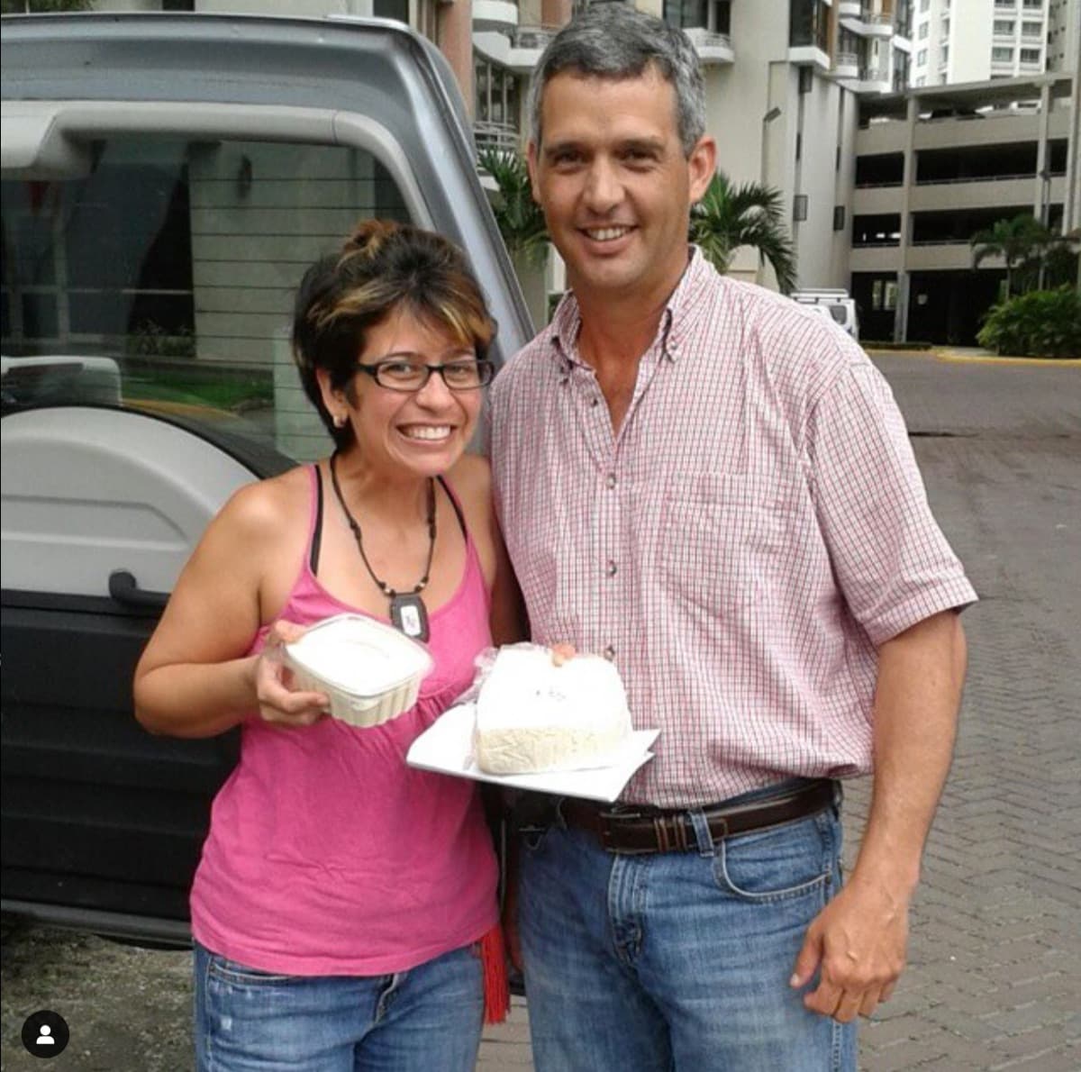 Dos personas sonríen con quesos recién entregados